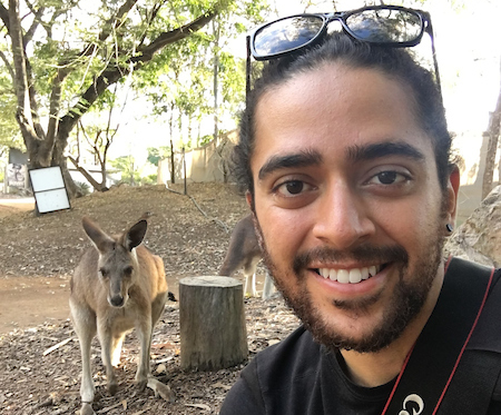 A student posing with a kangaroo in the background