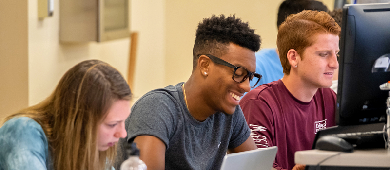 three students on computers