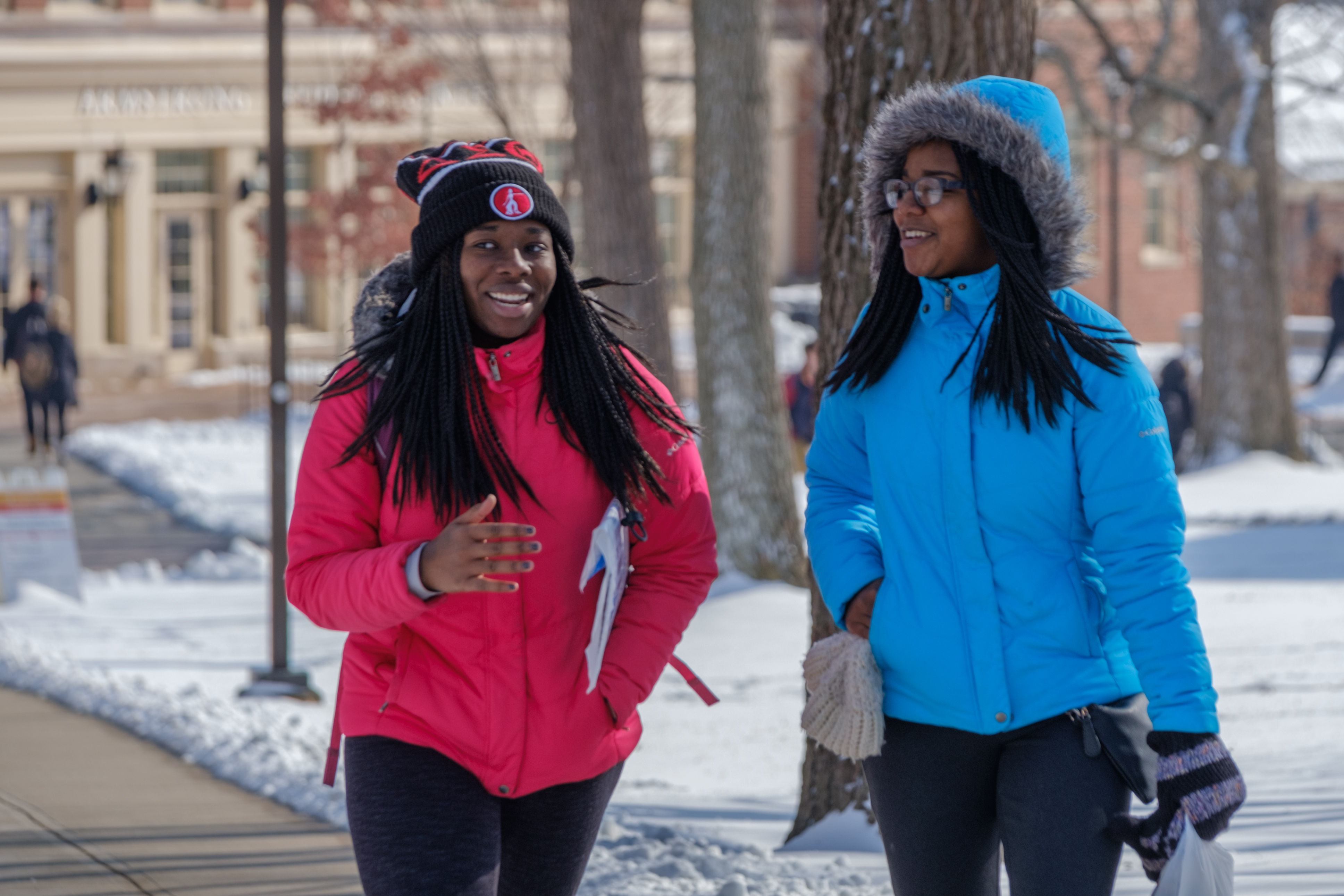 two students walking across campus in winter