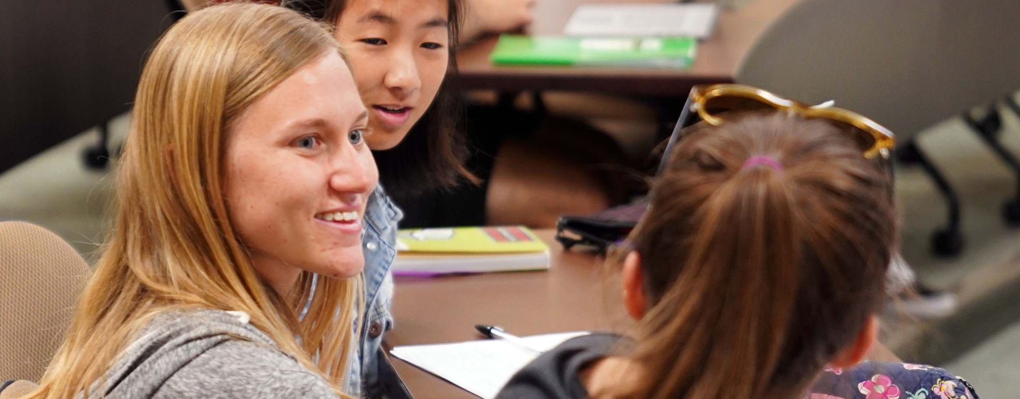 Woman smiles while talking to classmate