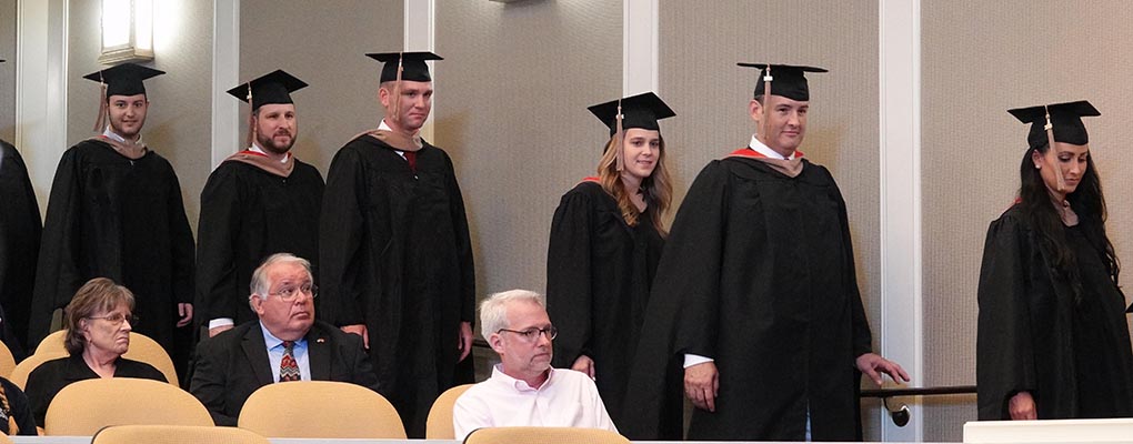 MBA graduates line up at graduation