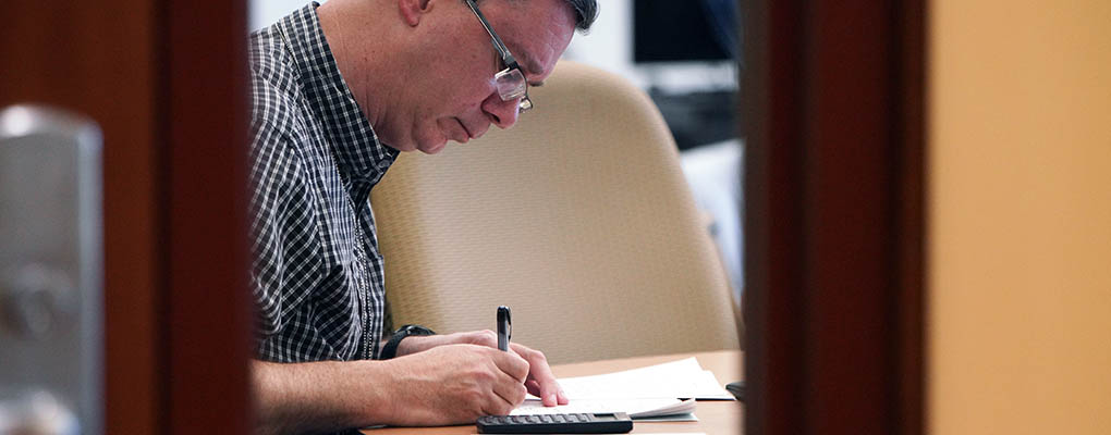 Man behind door takes exam on paper