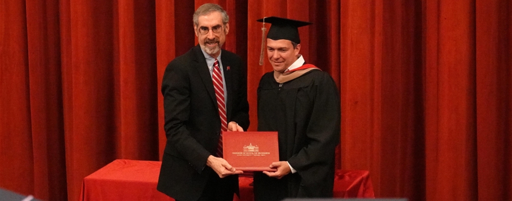 Dean Marc Rubin presents a diploma at graduation