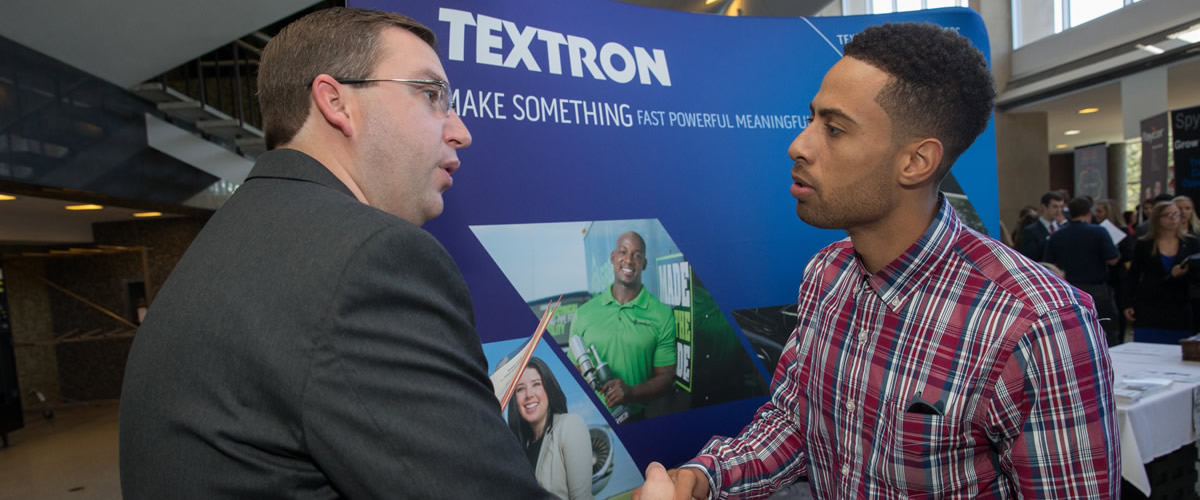 textron recruiter shaking hands with interested student at career fair