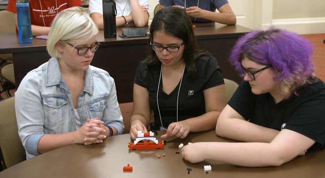 Trio of students with Legos at table