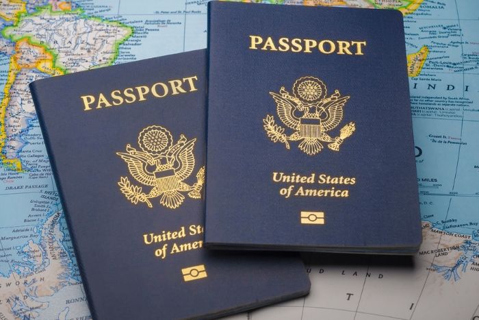 Two US passports on top of a map of the world