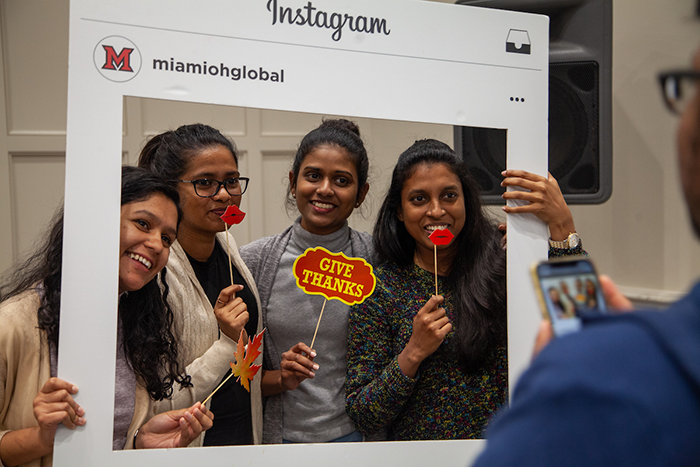 Students pose with an Instagram frame at the annual Thanksgiving Dinner
