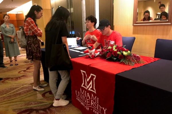  Miami student volunteers working check-in table at pre-orientation in China