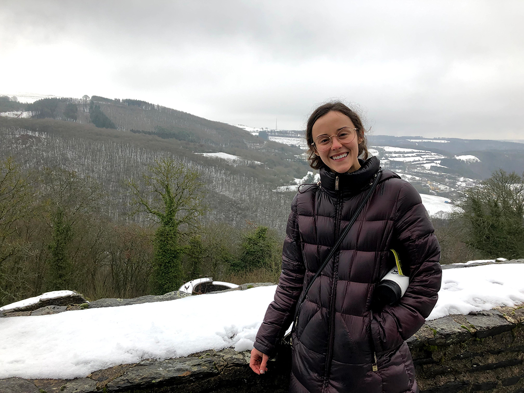 Grace stands near an overlook with snow-covered land and surfaces