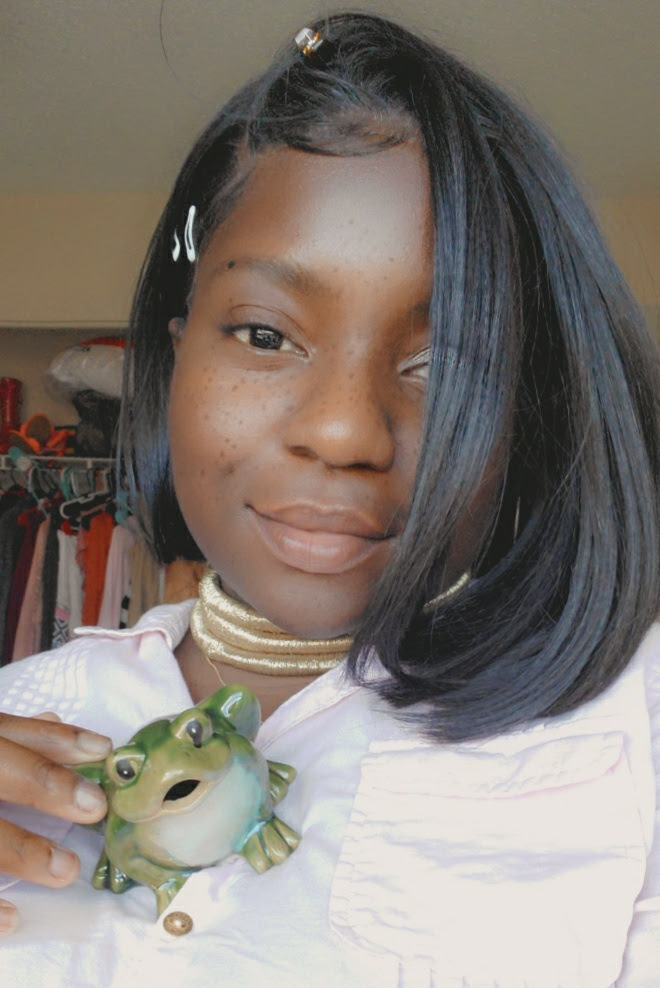 Leanne holds a small frog and looks at the camera