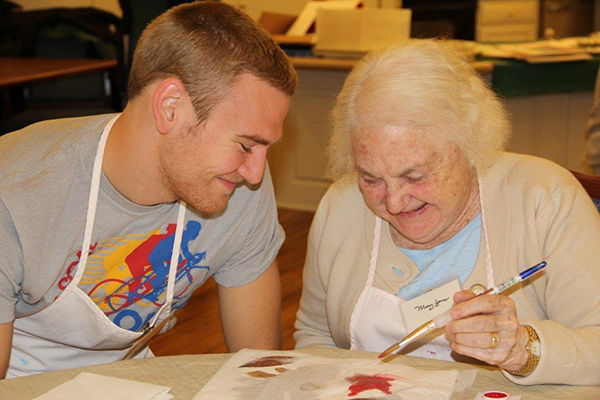 Student and participant work on an artwork