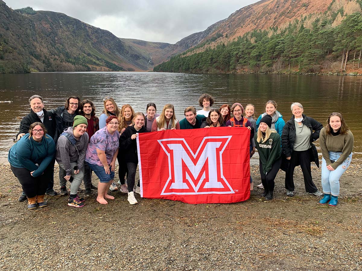 Miami students pose with M flag near lake in Ireland