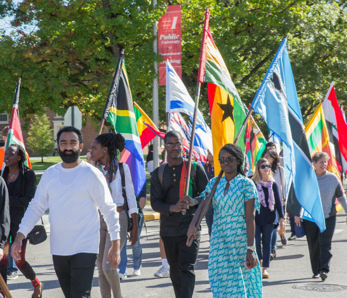  Group of international graduate students carrying a flag from their home country