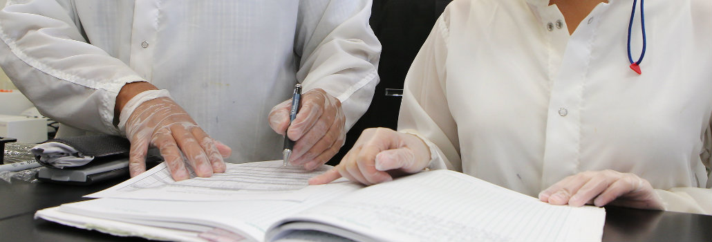  Two students working together in a lab looking at a lab manual