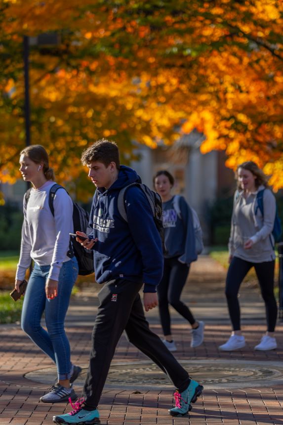 Students walk outside on campus during fall.