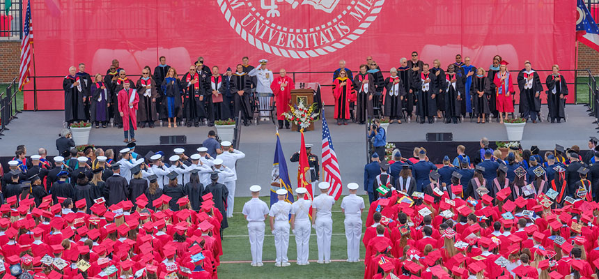 The Color Guard faces the stage at graduation, with military students and graduates on either side