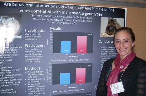 Brittney Graham stands in front of a poster detailing her research