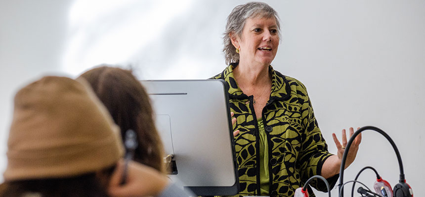  Professor Carolyn Keiffer teaching behind a desk. 
