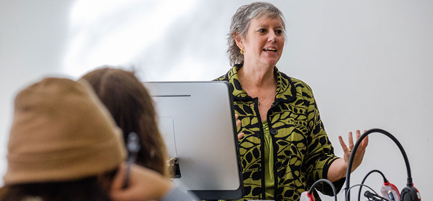 Professor Carolyn Keiffer teaching behind a desk.