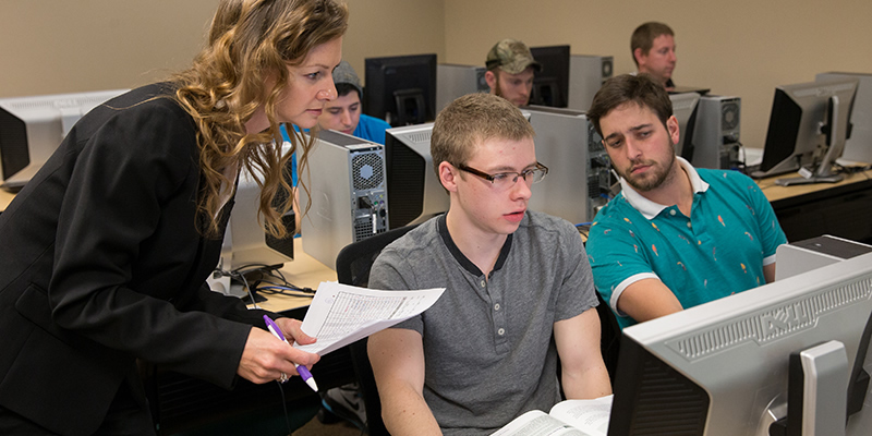 A professor talking to her students during a business software class.