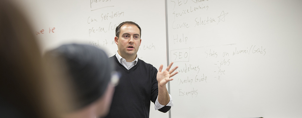 Professor Jeff Kuznekoff standing in the front of the room teaching. 