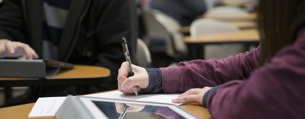  A student writing on a piece of paper during class.