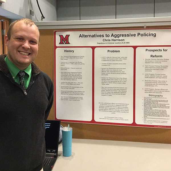 Chris Harrison standing next to his poster during the Criminal Justice Poster Session on Dec. 3