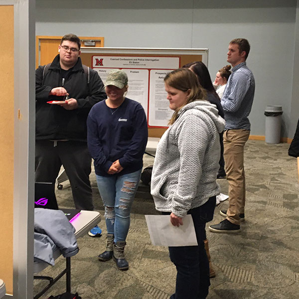 Students looking at a poster during the Criminal Justice Poster Session on Dec. 3 