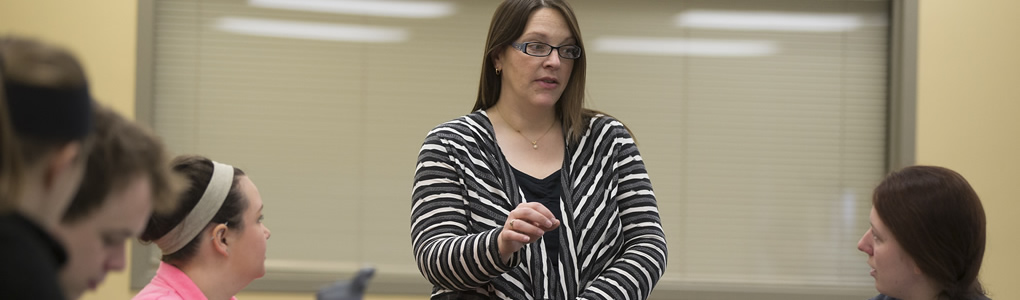 A Spanish professor talking to a student one-on-one during class time.