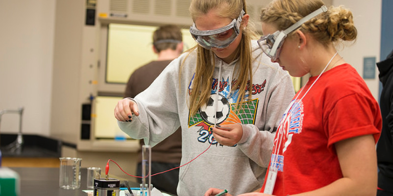 Two HS students electroplating iron nails in lab.