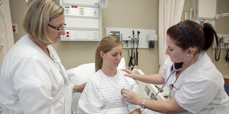 A student checking a patients vitals.  