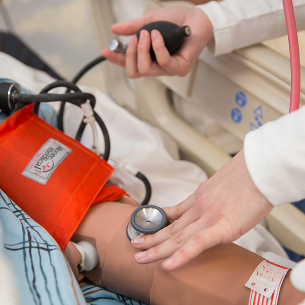 A student taking the simulation manikins temperature.