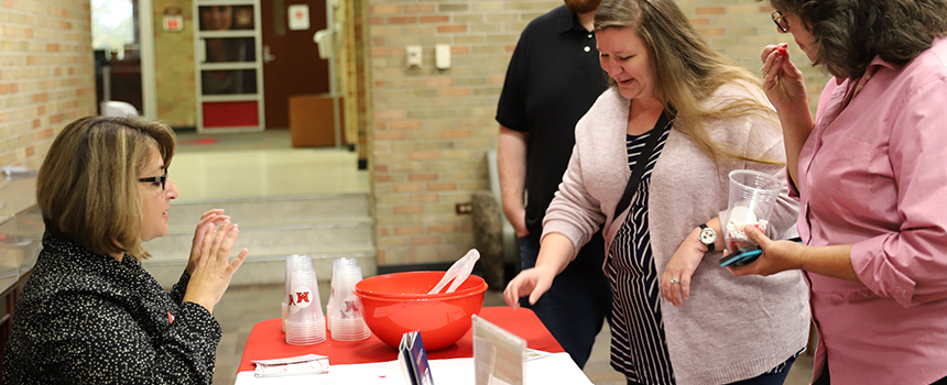 Ellen Paxton talking to people checking in during an event.