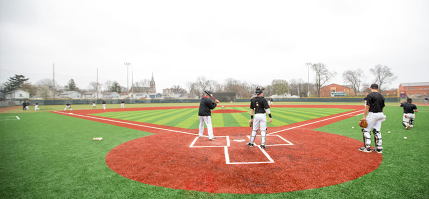 Harrier Baseball players taking infield during a game.