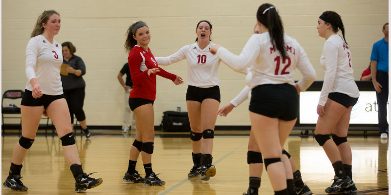 The volleyball team walking towards each other to go into a huddle