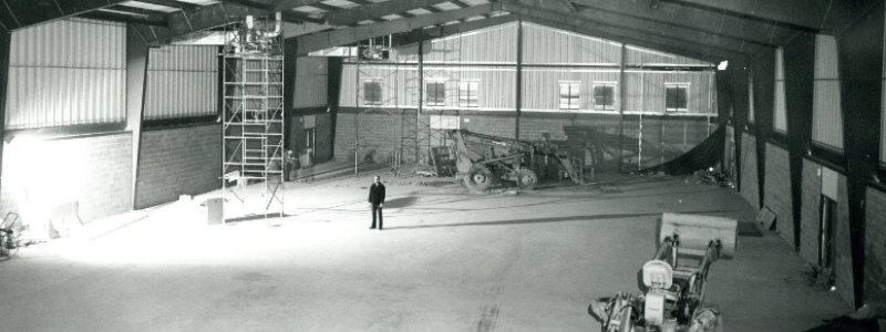 Lynn Darbyshire standing in the middle of the floor gym during its construction. 