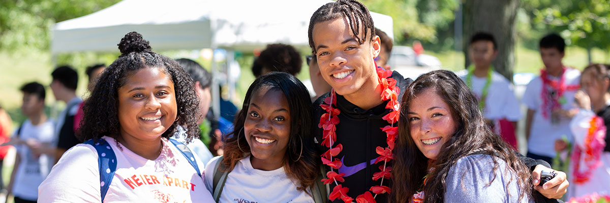 Students smiling at the camera while outside in the Middletown Quad during Fall Fest.
