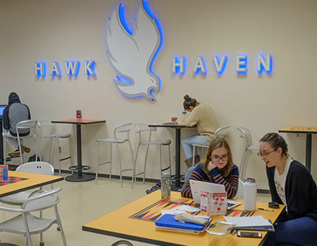 Students sitting at tables located in Hawk Haven on the Middletown Campus.