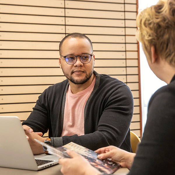 An adult student reviewing online courses with an advisor