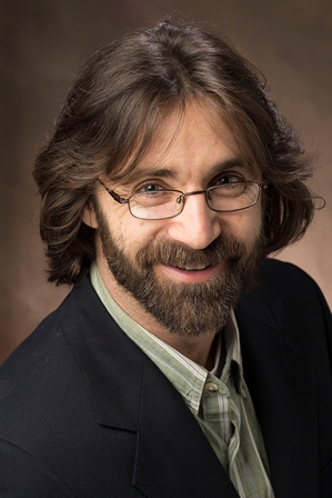 Robert Abowitz is a white male with long brown hair and a beard who is wearing a navy blazer.