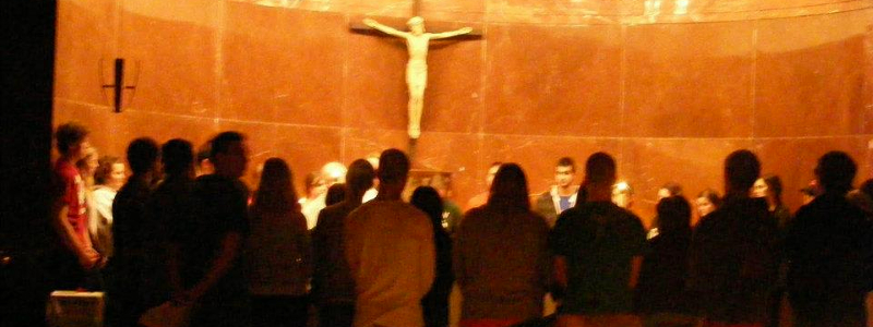 Students gather for worship in a circular shrine with a crucifix
