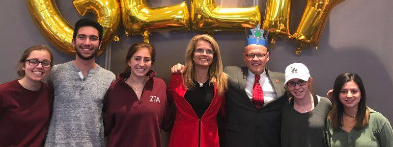 Greg and Renate Crawford pose with students at a Chanukah party