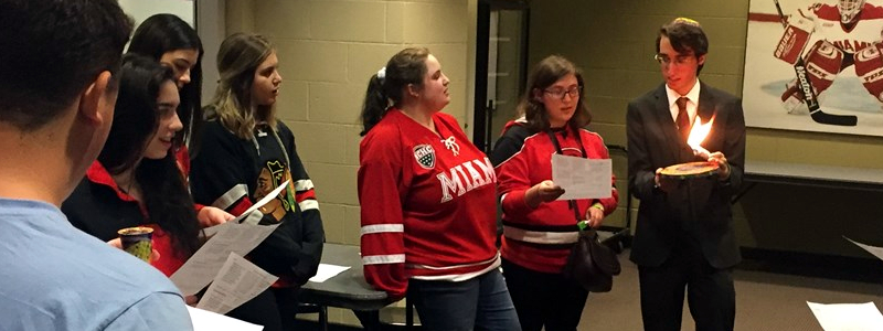 Miami students in hockey gear celebrating Havdalah