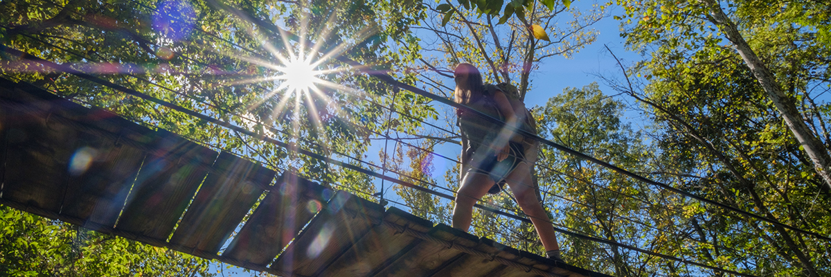 hiker crossing a bridge 