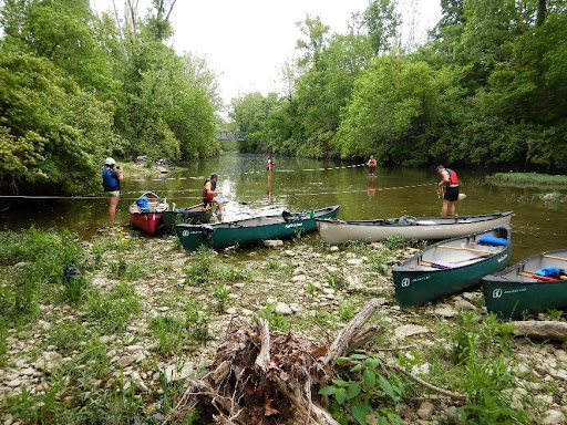Students wearing life jackets and wading through a river, taking various measurements