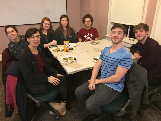  8 people seated around a table looking at the camera