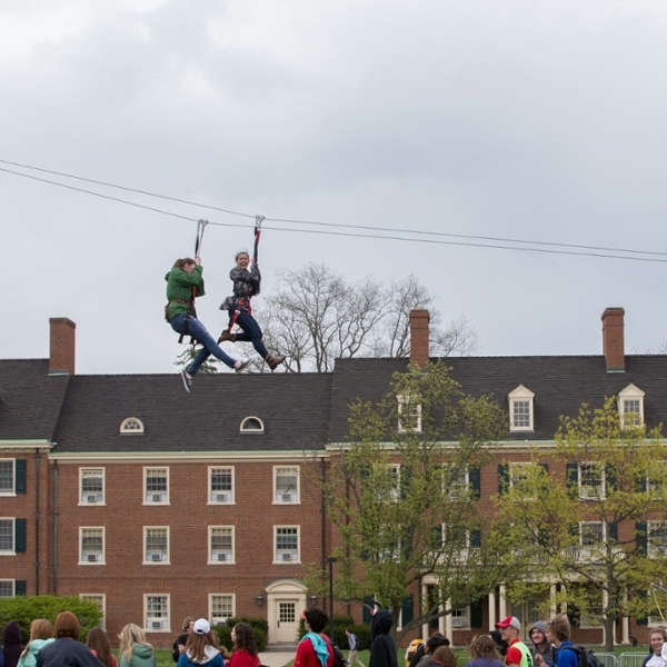  Two students ziplining across Central Quad