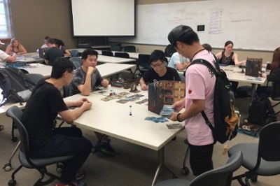Groups of students from EDL290 Table Top Games and Leadership playing the same game on various tables