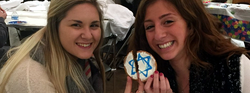  Two students sharing a cookie decorated with the Star of David