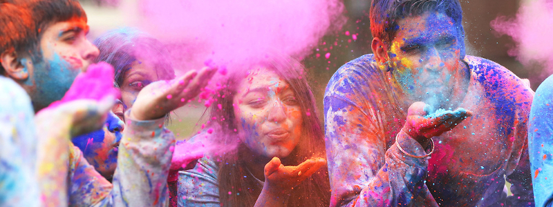  Students scatter colored powder during a Holi celebration
